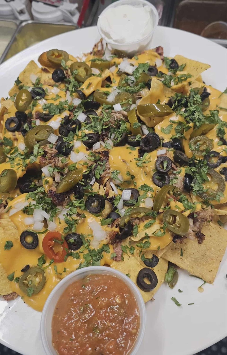 Super nachos with pulled pork and house cheese sauce
